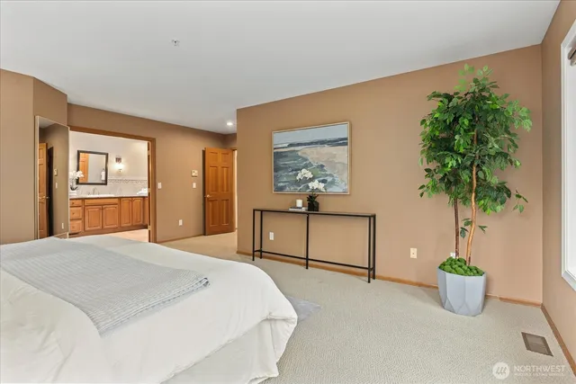 a bedroom with a large bed and a potted plant