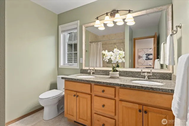 a bathroom with a granite countertop sink a toilet and a mirror