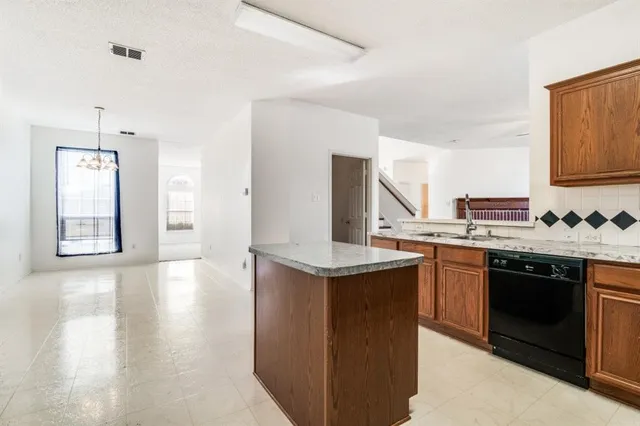 a kitchen with granite countertop a sink and a stove