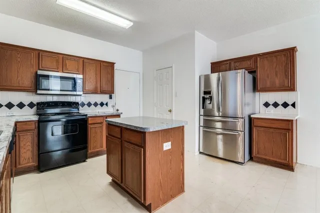 a kitchen with stainless steel appliances granite countertop a refrigerator stove and sink