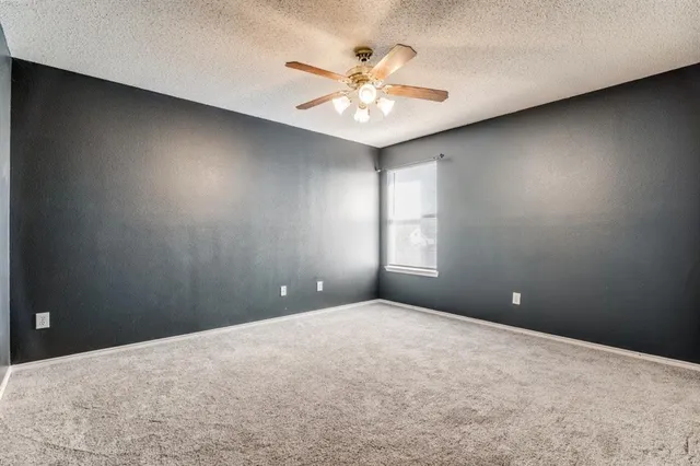 a view of an empty room and chandelier fan
