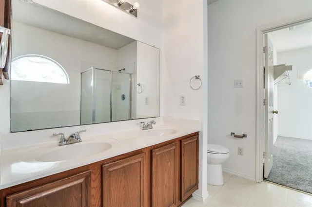 a bathroom with a granite countertop sink toilet a large mirror a vanity and shower