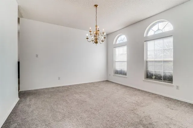 an empty room with windows and chandelier
