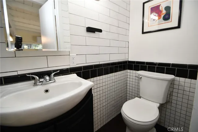 a bathroom with a toilet a sink and mirror