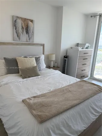 a bedroom with a bed and painting on the wall