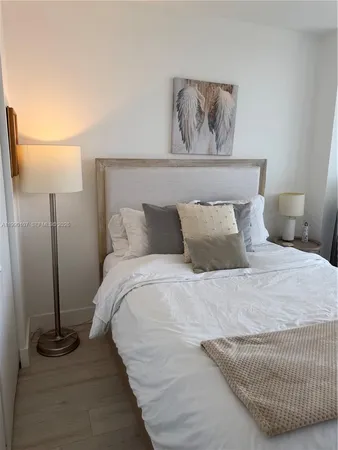 a bedroom with a bed and a painting on the wall