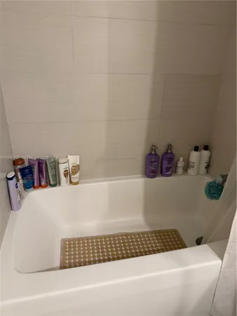 a bathroom with a bathtub and a shelf