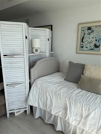 a bedroom with a bed and a wall painting