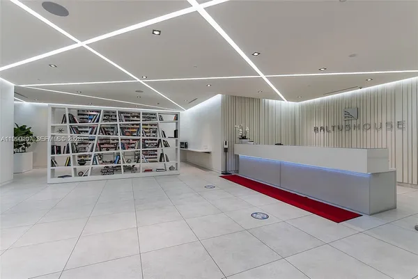 a view of an empty room with a window and chandelier