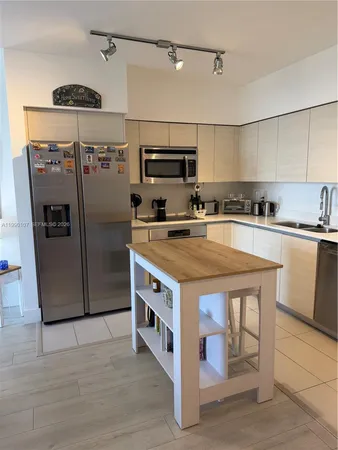 a kitchen with stainless steel appliances granite countertop a sink a stove and a refrigerator