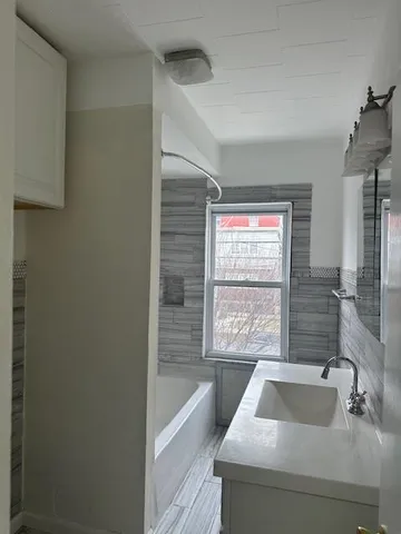 a bathroom with a sink a bathtub and window