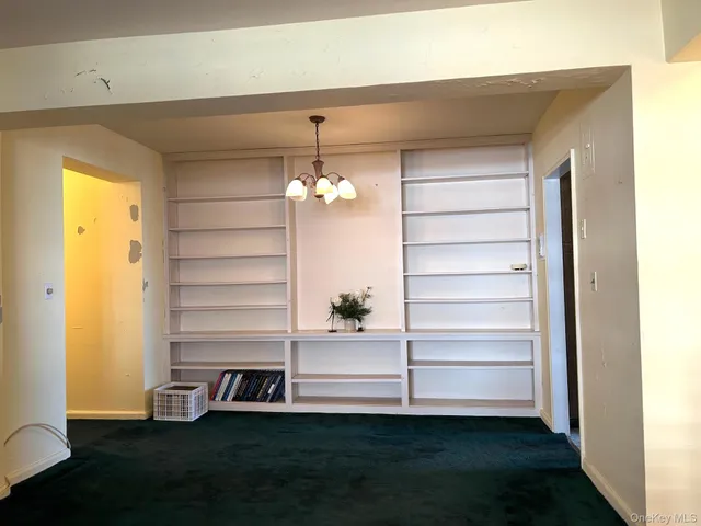 a view of a bedroom with a dresser and a chandelier