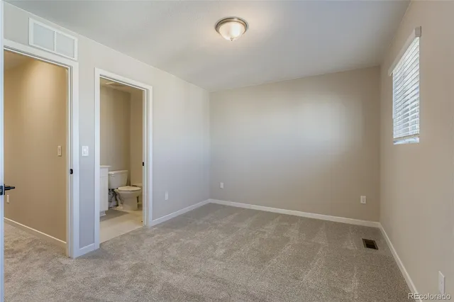 an empty room with closet and a window