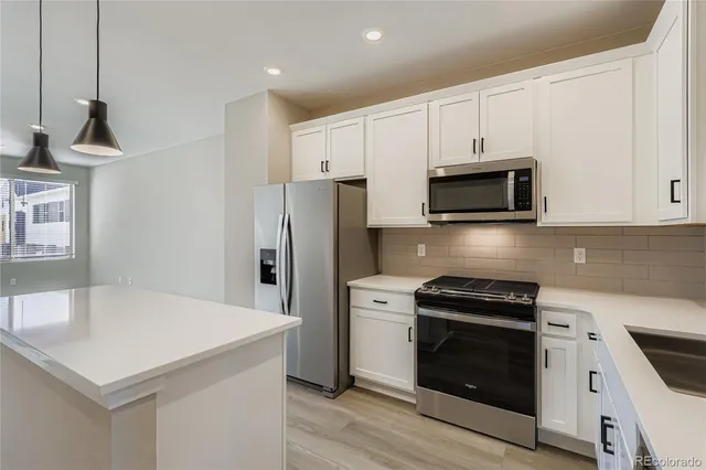 a kitchen with stainless steel appliances a stove microwave and refrigerator