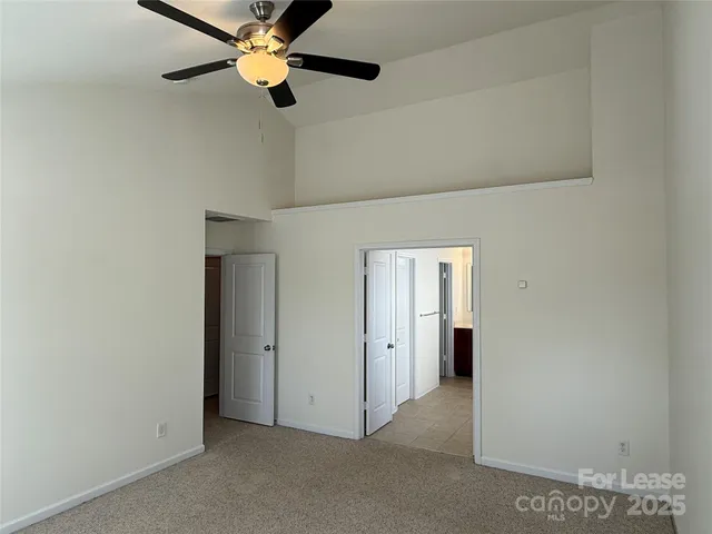 an empty room with closet and a chandelier fan