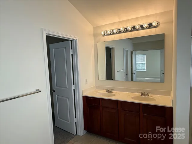 a bathroom with a double vanity sink and mirror
