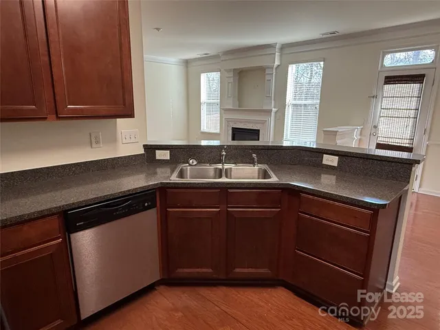 a kitchen with granite countertop cabinets sink and window