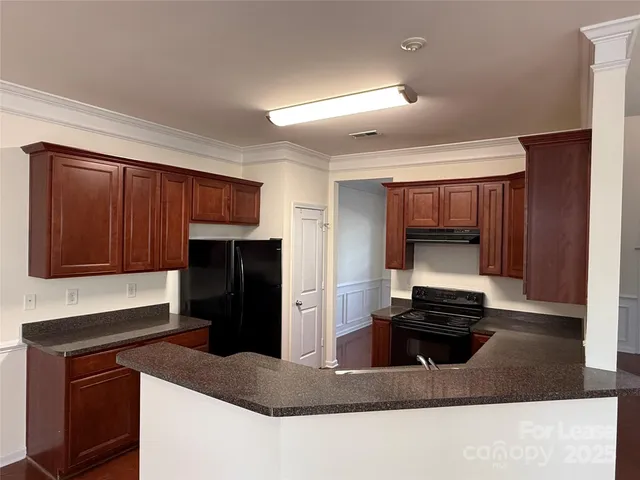 a kitchen with kitchen island a cabinets and black appliances
