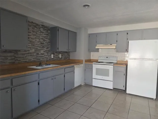 a kitchen with white cabinets and white appliances