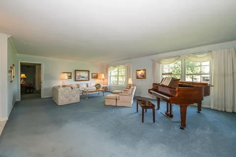 a living room with furniture and a piano