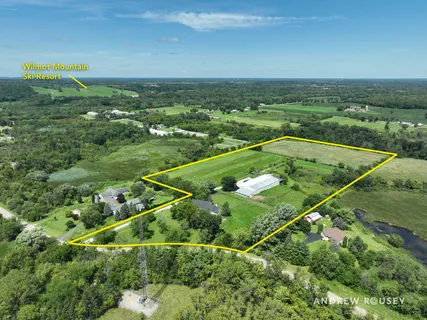 an aerial view of residential houses with outdoor space and trees