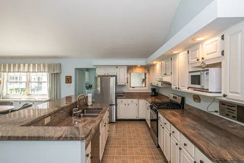 a kitchen with stainless steel appliances granite countertop a sink stove and refrigerator