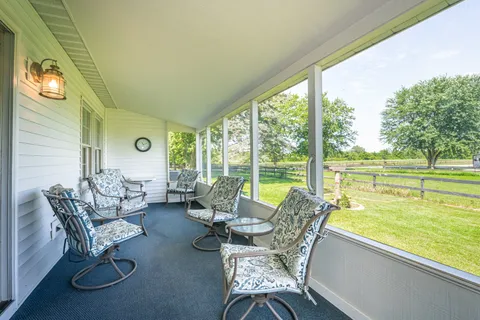 a living room with furniture and floor to ceiling windows