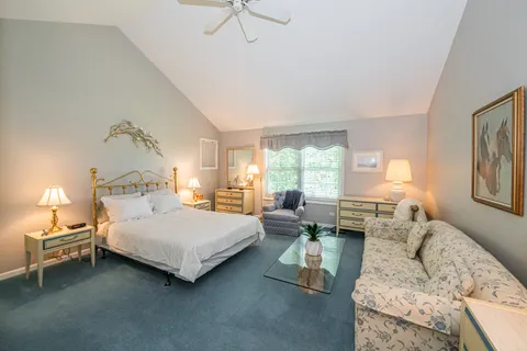 a bedroom with double bed windows and a couch