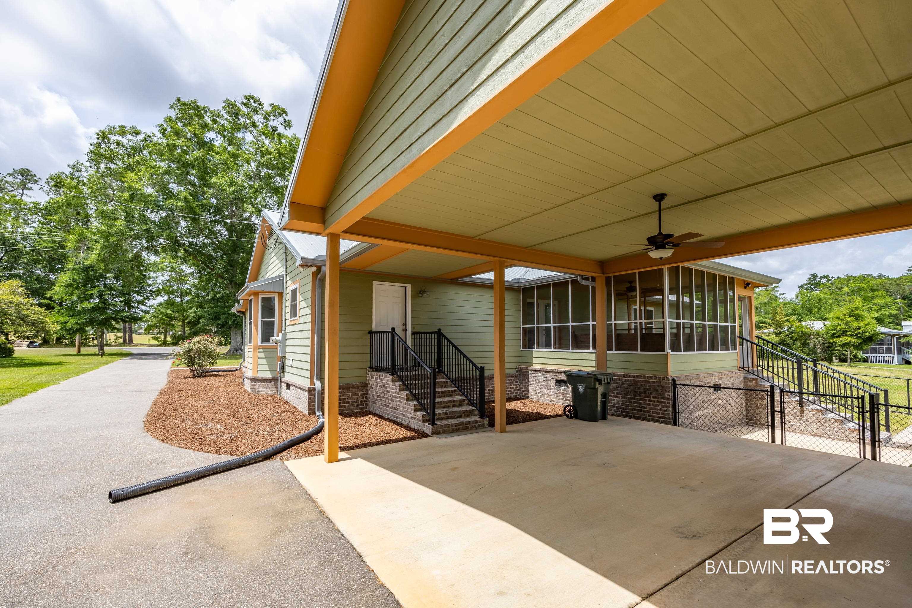 9771 Clarke Ridge Road Foley, AL 36535 - Photo 20 of 72 View of patio / terrace with a ceiling fan, a sunroom, and a carport.