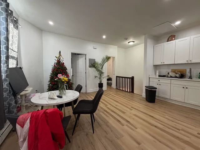 a kitchen with a dining table chairs and wooden floor