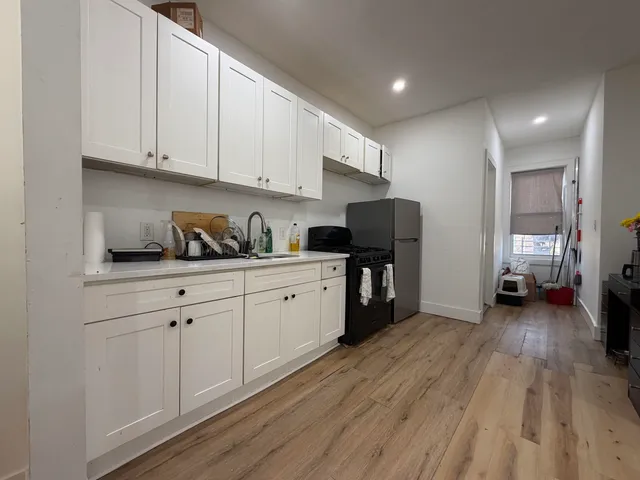 a kitchen with sink cabinets and wooden floor