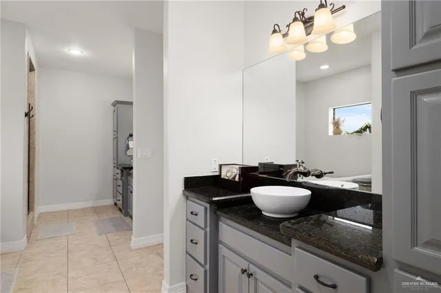 a bathroom with a granite countertop sink a mirror and a shower