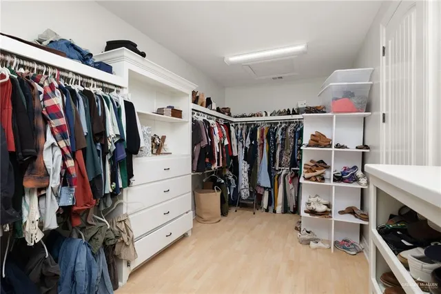 a view of walk in closet with clothes and shoes