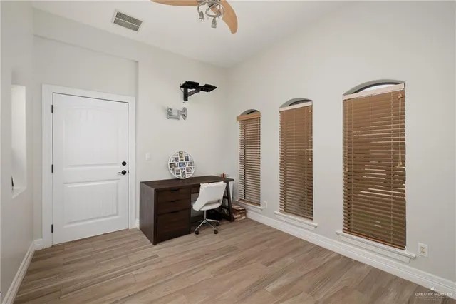 a view of a workspace with furniture and a window