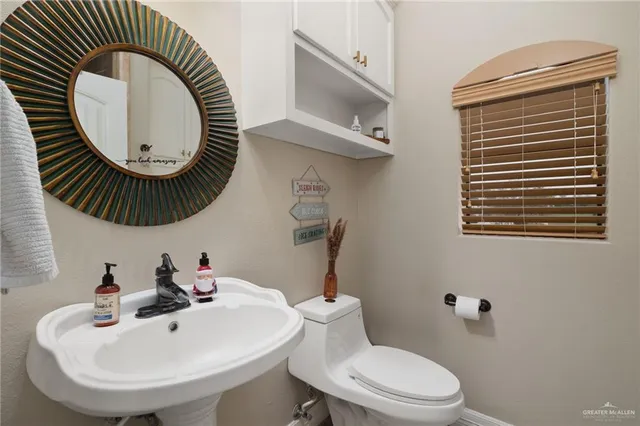 a bathroom with a sink a toilet and a mirror