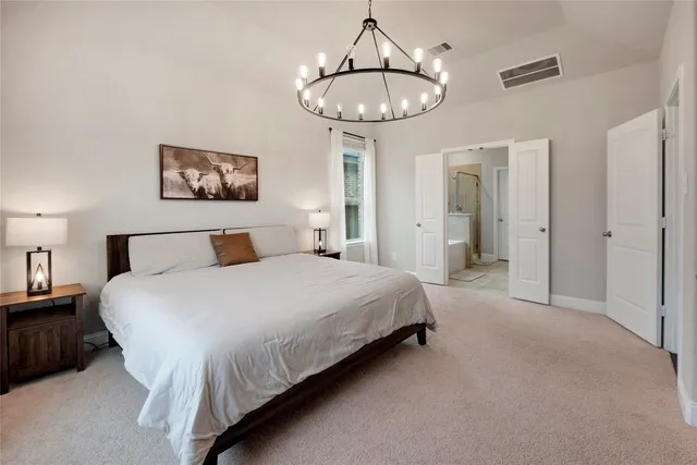 a bedroom with bed and a chandelier