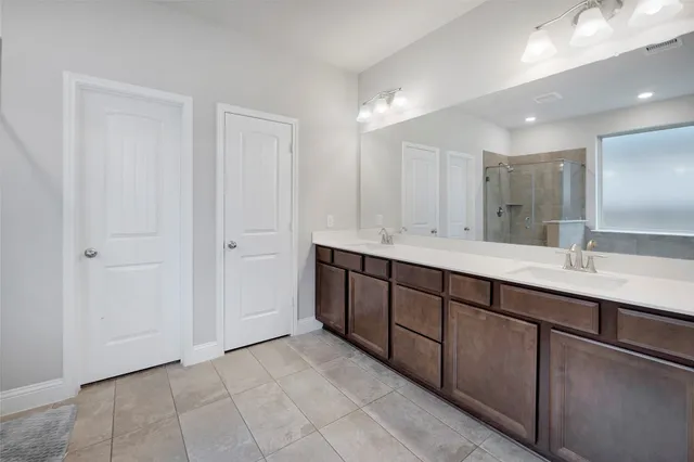 a spacious bathroom with a double vanity sink and a mirror