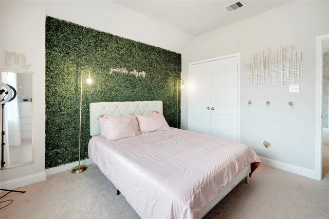 a bedroom with a bed and a large mirror