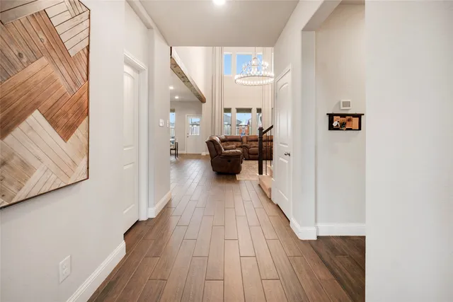 a view of a hallway with wooden floor and furniture