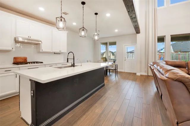 a kitchen with a sink a counter space and wooden floor