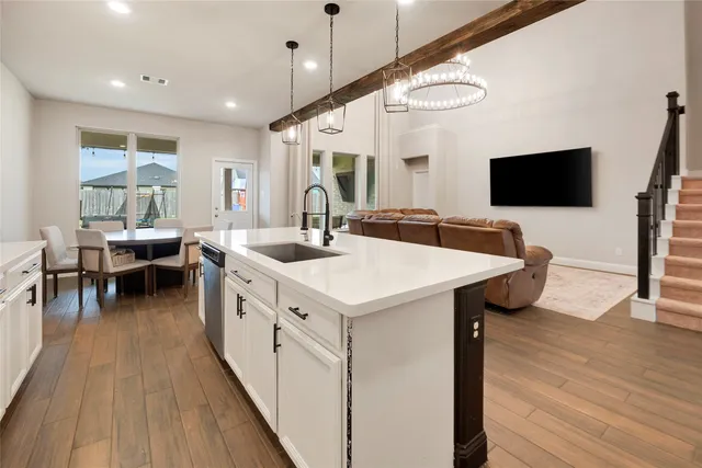 a kitchen with a sink and wooden floor