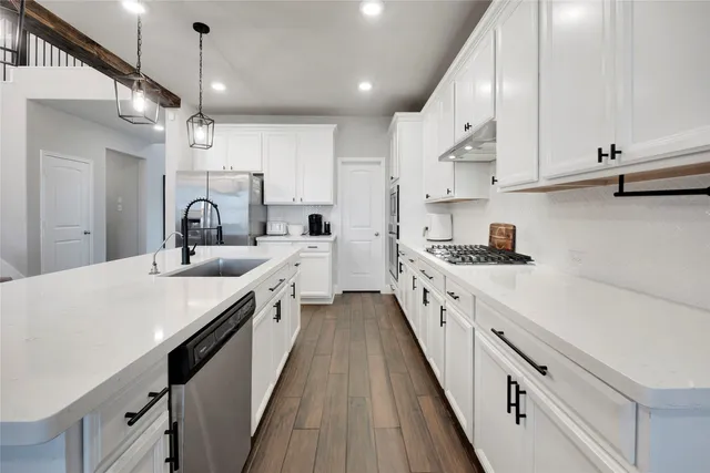 a large kitchen with cabinets and wooden floor