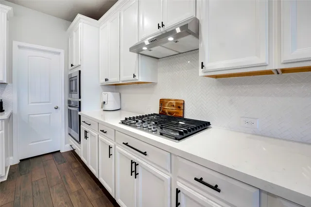 a kitchen with stainless steel appliances a white stove top oven and cabinets