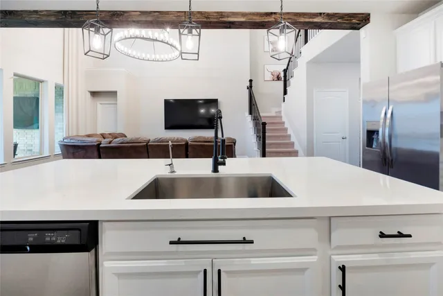 a close view of a sink a counter and a refrigerator in a kitchen
