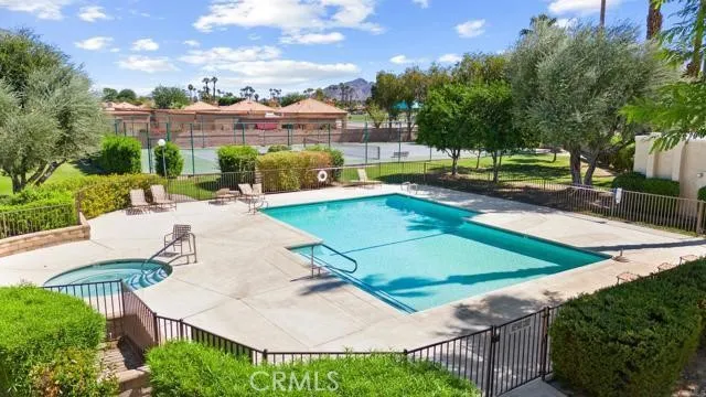 a view of a swimming pool with a patio and a yard