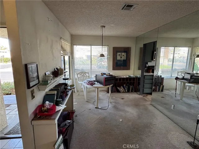 a living room with furniture a flat screen tv and large window