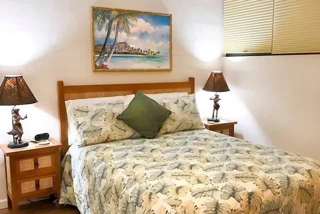 a bedroom with a bed and a painting on the wall