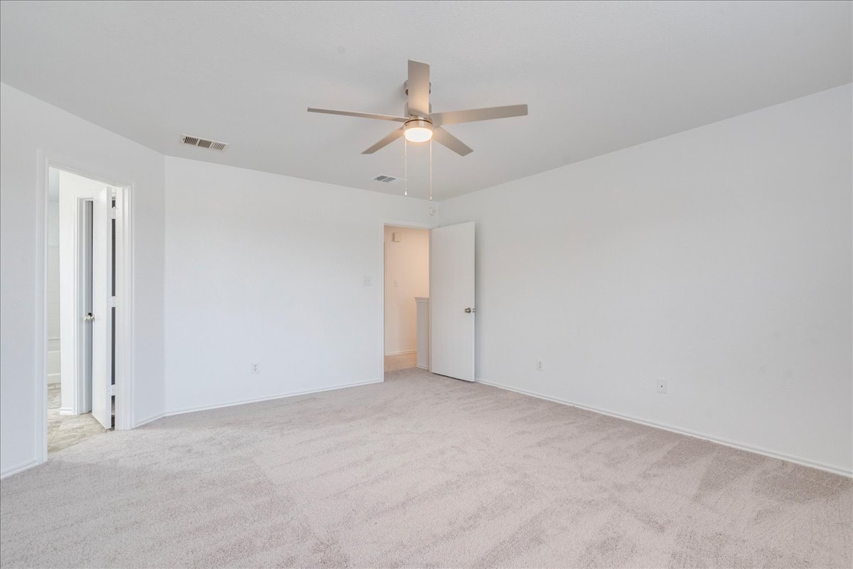 618 Lavaca Loop Elgin, TX 78621 - Photo 14 of 30 Unfurnished bedroom featuring light carpet and ceiling fan