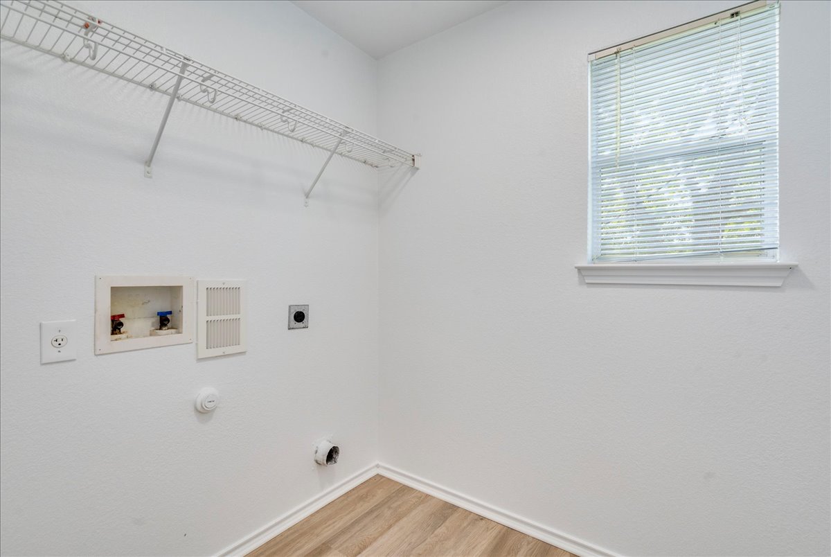 618 Lavaca Loop Elgin, TX 78621 - Photo 24 of 30 Laundry room featuring hookup for a washing machine, hookup for a gas dryer, light wood-style floors, and electric dryer hookup