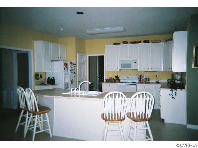 1113 Goswick Ridge Road Midlothian, VA 23114 - Photo 4 of 5 a kitchen with a dining table chairs and refrigerator